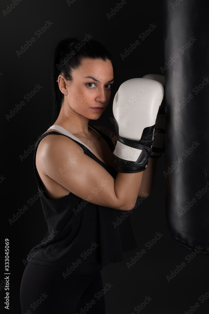 Female kickboxer training with a punching bag Female kickboxer training with a punching bag
