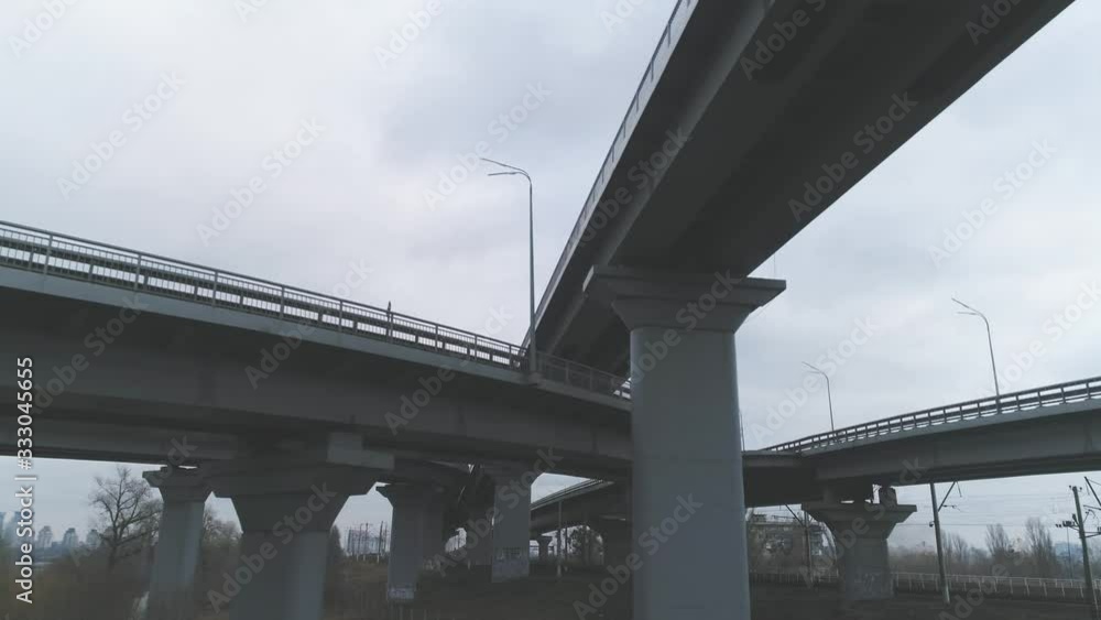 Darnitsky bridge over the Dnieper River. Ukraine city Kiev. Video from the drone. Span of a drone under a bridge with a departure to the track Darnitsky bridge over the Dnieper River. Ukraine city Kiev. Video from the drone. Span of a drone under a bridge with a departure to the track