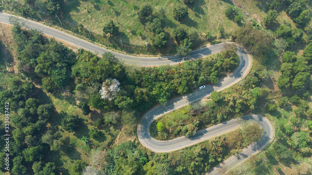 Aerial view of asphalt winding road in the forest mountain for background.Scenic view of Sharp curve road by drone safty drive and travel concept. Aerial view of asphalt winding road in the forest mountain for background.Scenic view of Sharp curve road by drone safty drive and travel concept.