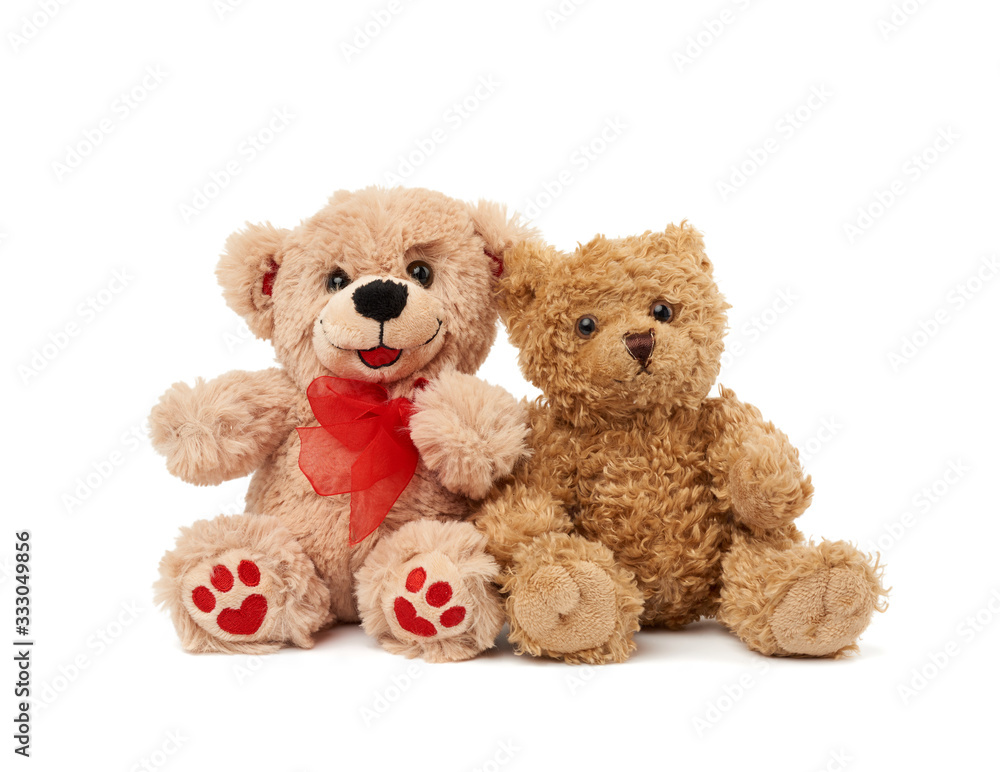 two teddy beige bears sitting huddled together two teddy beige bears sitting huddled together