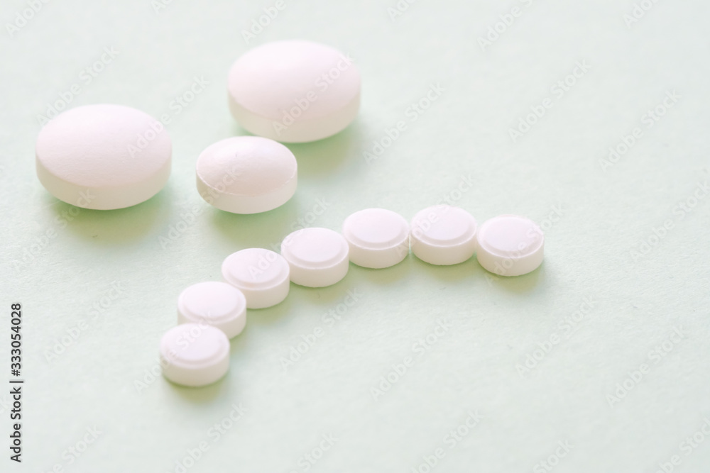 Sad patient face made from white round pills on green Sad patient face made from white round pills on green