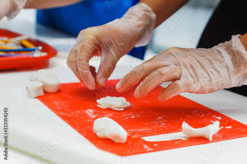 Confectioner on a blue board makes cookies from forms