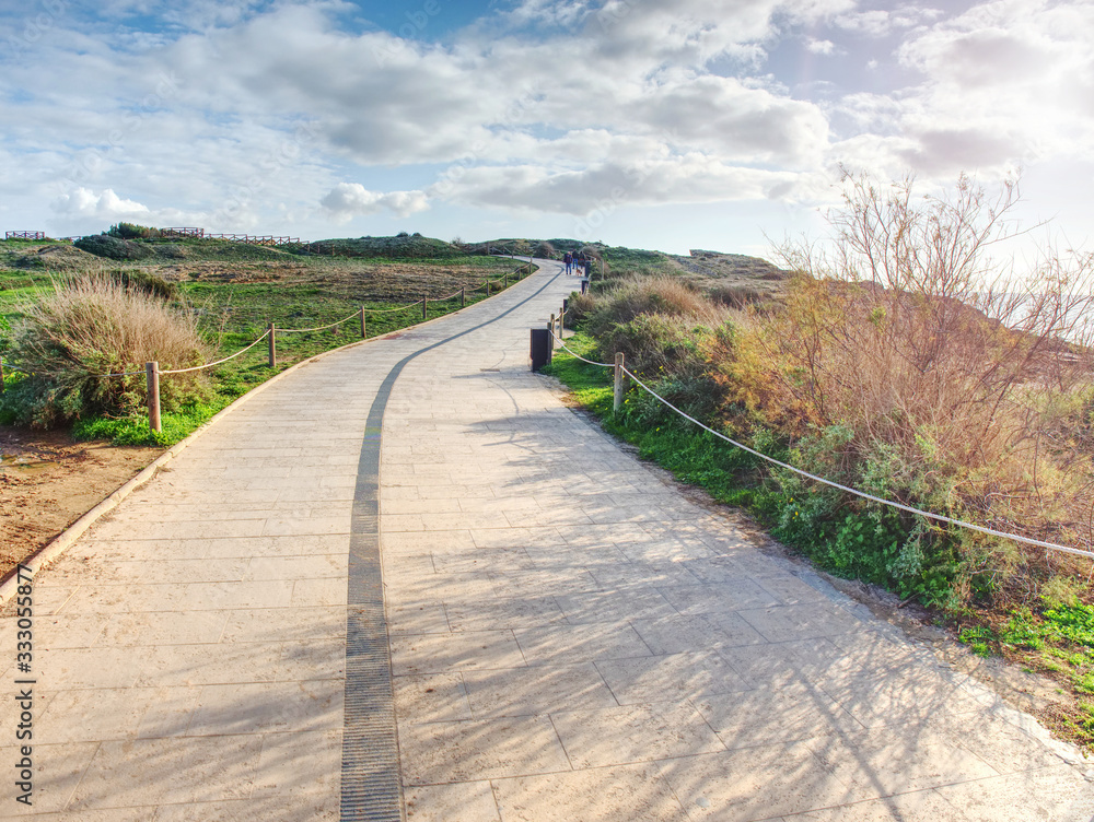 Stony tilled paved footpath at sea, dark stripe Stony tilled paved footpath at sea, dark stripe