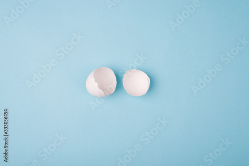 Top overhead above photo of cracked egg isolated ob blue color background with empty blank copy space for design
