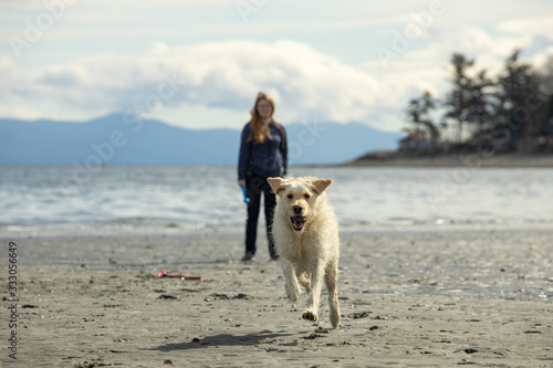 woman with dog on the beach on Vancouver Island, Canada