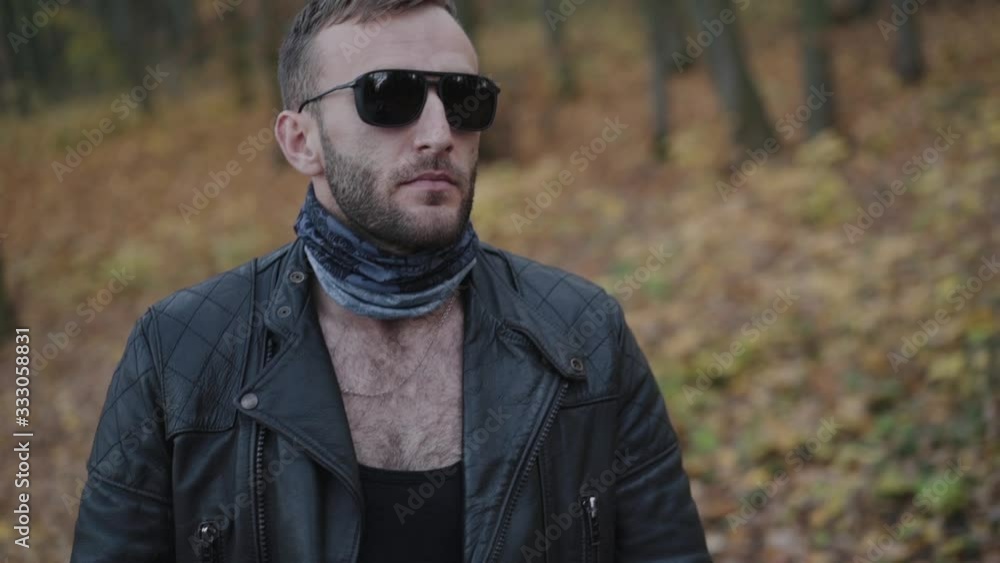 Brutal man in sunglasses walks to his lovely girl in autumn park Brutal man in sunglasses walks to his lovely girl in autumn park