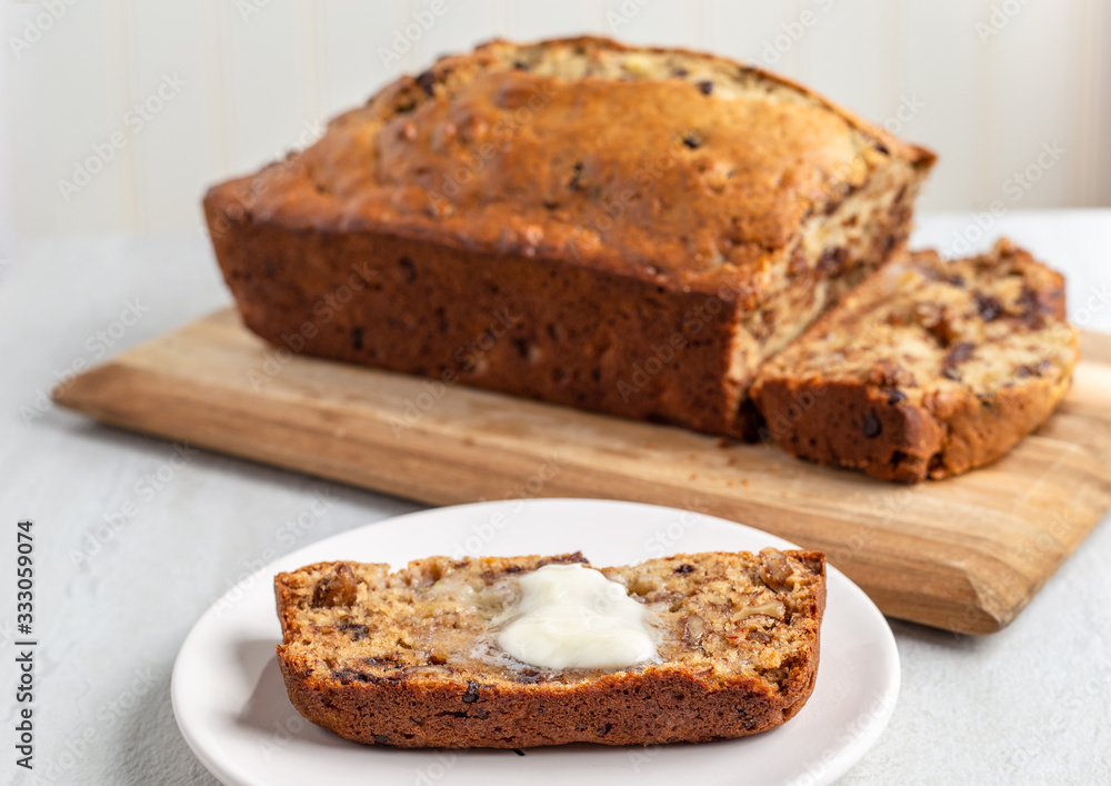Fresh banana bread, plated slice with melting butter Fresh banana bread, plated slice with melting butter