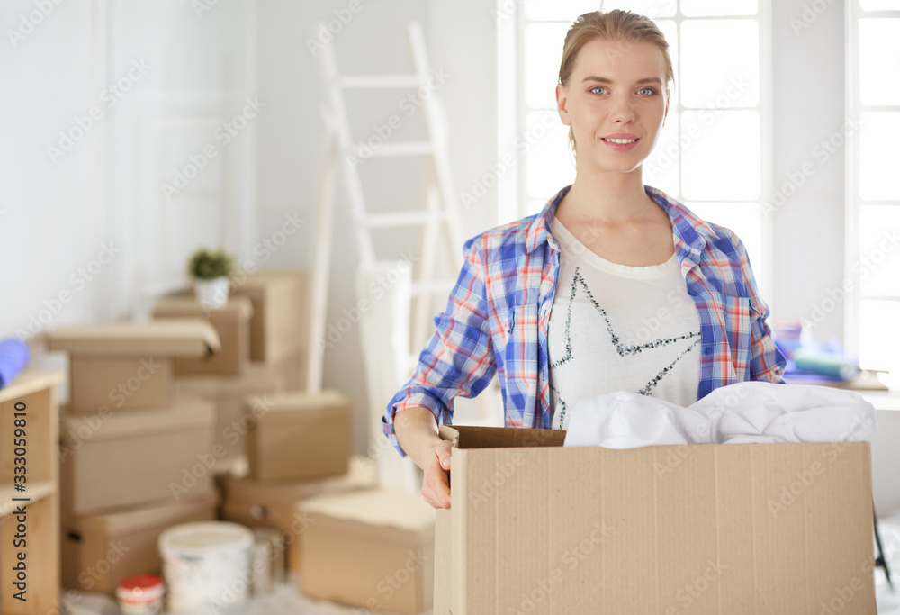 A beautiful single young woman unpacking boxes and moving into a new home A beautiful single young woman unpacking boxes and moving into a new home