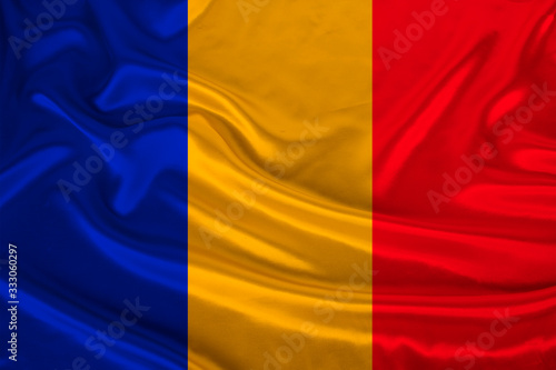 photo of the national flag of Romania on a luxurious texture of satin, silk with waves, folds and highlights, close-up, copy space, concept of travel, economy and state policy, illustration
