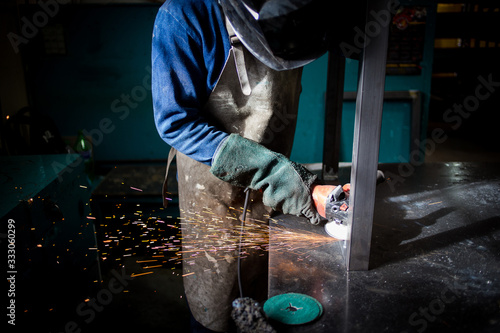 Close up image of an industrial worker working with an angle grinder © Dewald