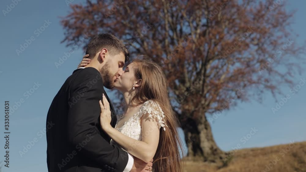 Newlyweds. Caucasian groom with bride near beautiful autumn tree. Wedding couple Newlyweds. Caucasian groom with bride near beautiful autumn tree. Wedding couple