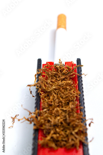 machine for driving tobacco into a sleeve with tobacco and sleeves on a white background. isolate