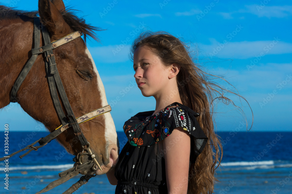 Dziewczynka z koniem na plaży spogląda w dal - obrazy, fototapety, plakaty 