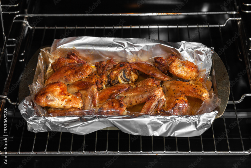 Oven baked chicken wings in the home kitchen. With a golden crispy crust. Close-up Oven baked chicken wings in the home kitchen. With a golden crispy crust. Close-up