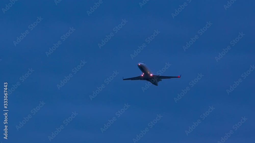 Generic Unmarked Regional Jet Airliner with Lights on Taking Off Flying into a Blue Night Sky Generic Unmarked Regional Jet Airliner with Lights on Taking Off Flying into a Blue Night Sky
