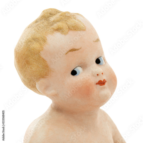 Face of vintage baby doll from ceramics closeup, isolated on white background