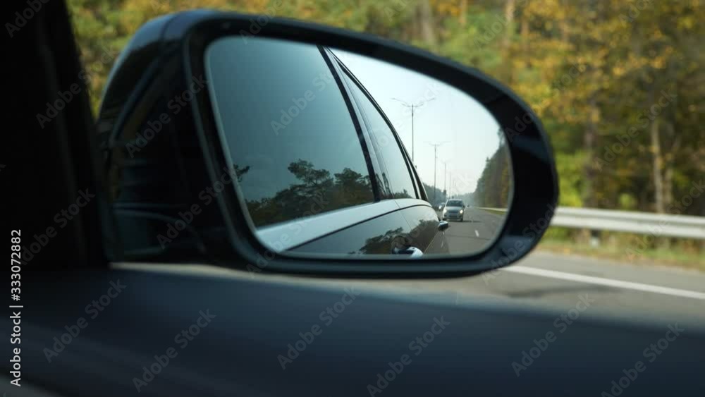 Close-up Side-view mirror Reflection Car Moving Behind Following on Highway. Bright Sunny Summer Autumn Morning Day, Blue Sky. 2x Slow motion 0.5 speed 60 FPS Close-up Side-view mirror Reflection Car Moving Behind Following on Highway. Bright Sunny Summer Autumn Morning Day, Blue Sky. 2x Slow motion 0.5 speed 60 FPS