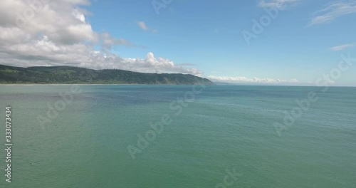 Flying backwards over coastline in northern California near Crescent City harbor. 