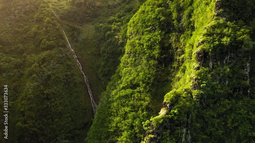 Haena State Park. Hawaii. Impressive aerial footage of green mountain slopes, densly covered with lush greenery. Bright tropical nature. The scene is lit with the sun. Aerial, 4K photo