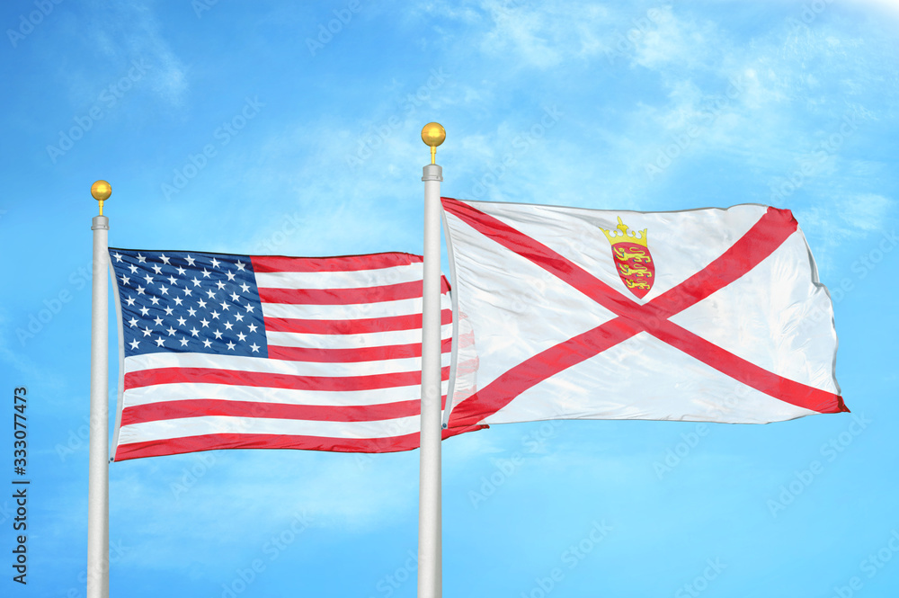 United States and Jersey two flags on flagpoles and blue cloudy sky United States and Jersey two flags on flagpoles and blue cloudy sky