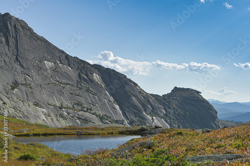 Fototapeta Naklejka Na Ścianę i Meble -  lake under rock ridge, autumn hiking in mountain valley