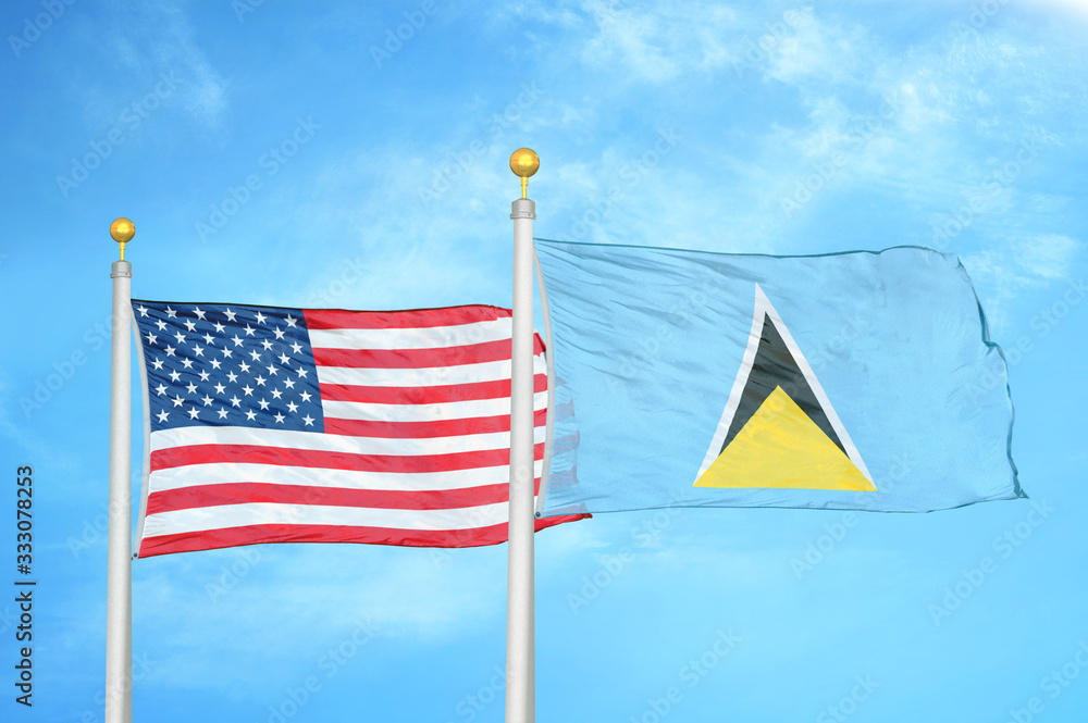 United States and Saint Lucia two flags on flagpoles and blue cloudy sky United States and Saint Lucia two flags on flagpoles and blue cloudy sky