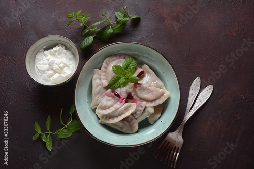 Dumplings with cherries,sour cream and mint. Ukrainian, Russian and Belarusian cuisine. Healthy breakfast