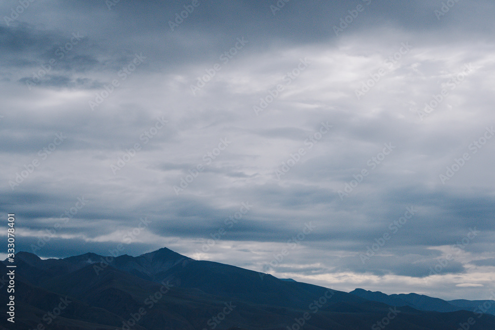 mountain valley under cloudy sky, rock ridge on horizon, hiking in  mountains, rest and meditation in nature