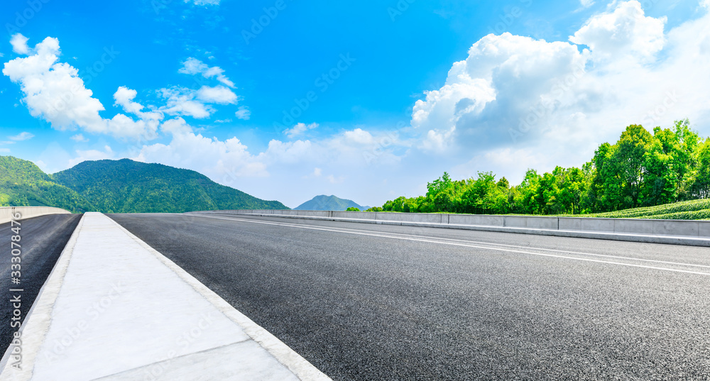 Asphalt road and green tea mountain nature landscape on sunny day,panoramic view.