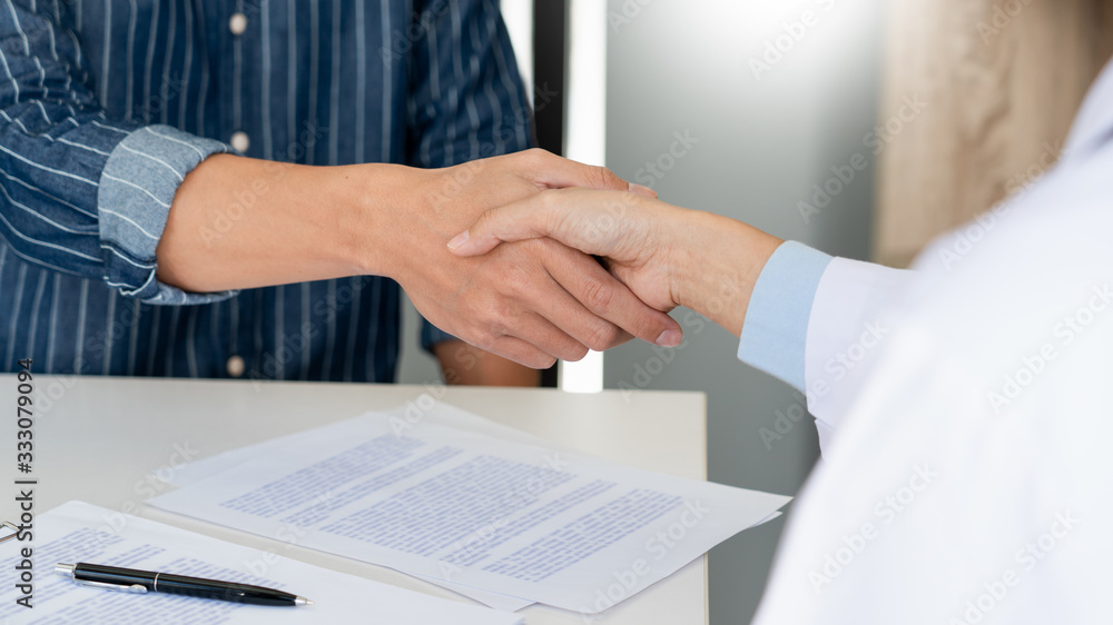 Attractive Doctor and patient shaking hands for encouragement and empathy, healthcare and assistance, Medical concept. Attractive Doctor and patient shaking hands for encouragement and empathy, healthcare and assistance, Medical concept.