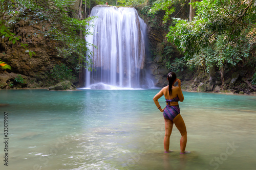 Woman with swimsuit happy in water at Erawan Waterfall and  natural