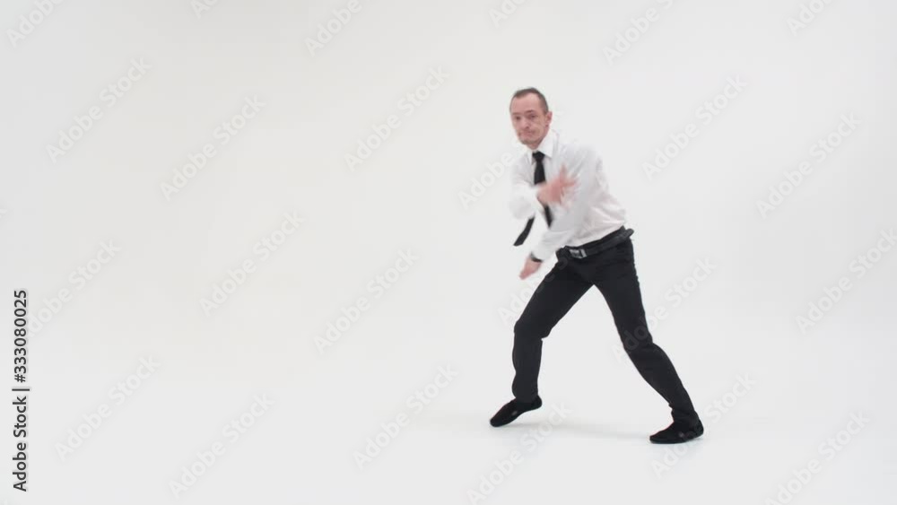 A man in office clothes is dancing a break dance. An office worker dances a break dance and makes a twist movement A man in office clothes is dancing a break dance. An office worker dances a break dance and makes a twist movement