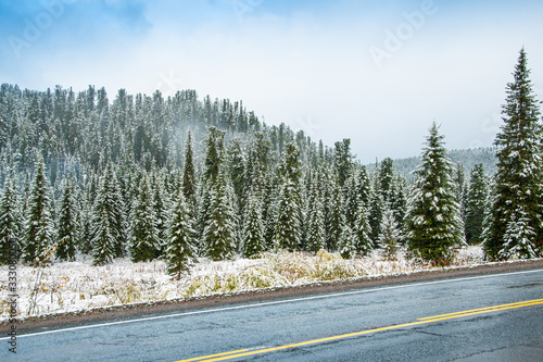 ice on winter asphalt road, road trip to mountains, roadbed in woods, dangerous cold snap on way photo