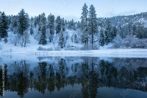 mountains and forest reflecting in lake during winter © Attila Adam