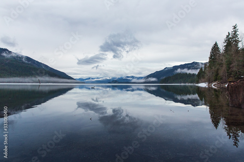 Clouds, trees and mountains reflecting in Kachess Lake, Washington