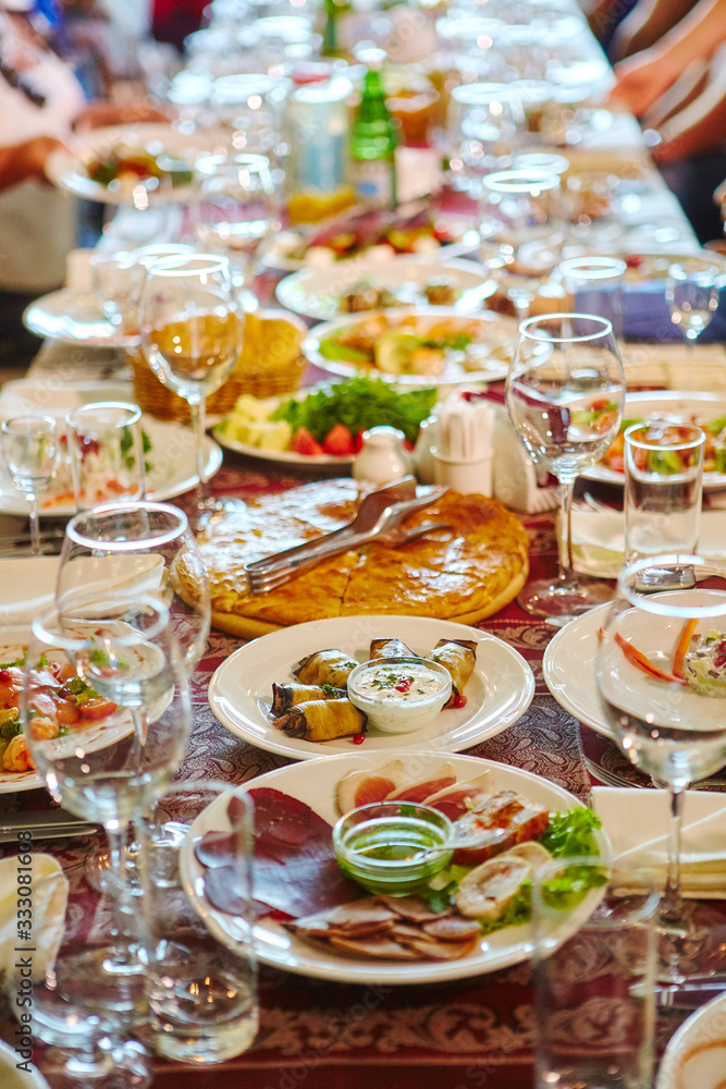 Long Banquet table. Drinks and snacks on the table.  People are sitting at the table. Concept of joint celebrations