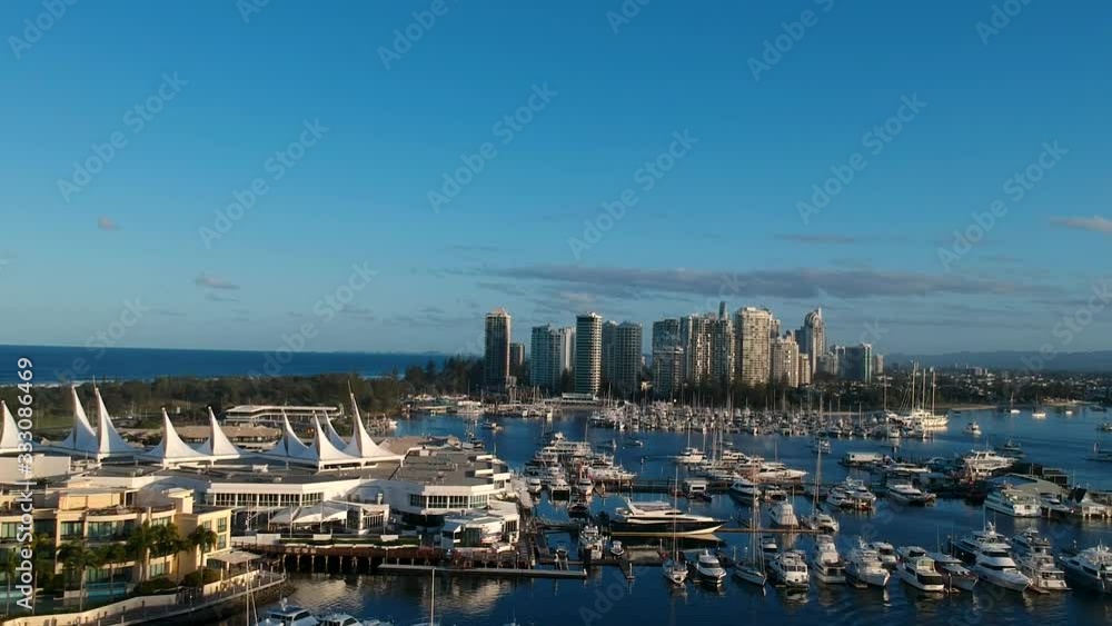 Fast moving drone video revealing a large marina close to a towering coastal city skyline Fast moving drone video revealing a large marina close to a towering coastal city skyline