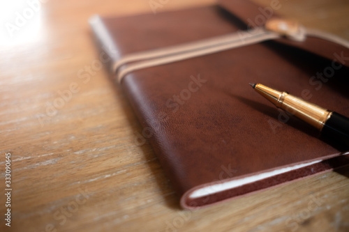defocus pen and vintage diary on wooden table