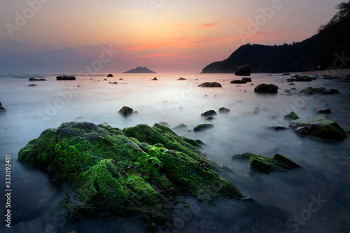 Sea sunset with rock and green moss beautiful, krating bay ‎Chanthaburi thailand.