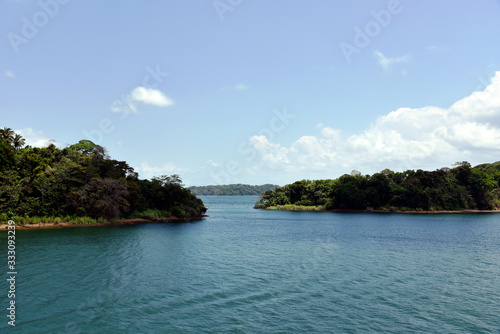 Green landscape of Panama Canal, view from the transiting cargo ship.