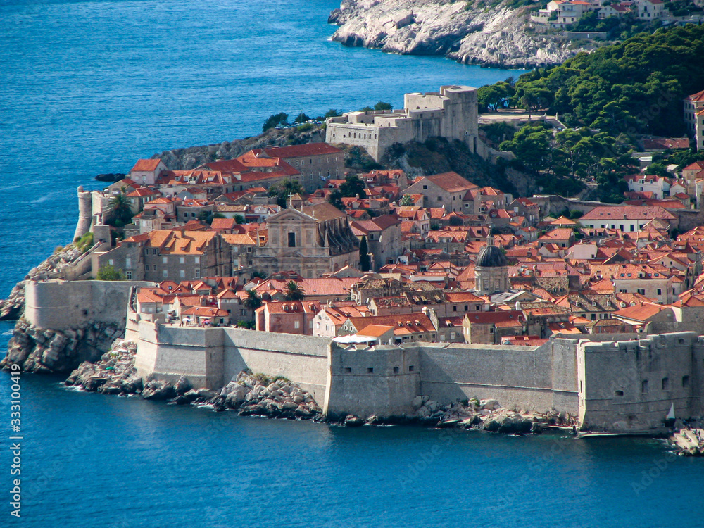 View of the fortress wall and the city of Dubrovnik on a sunny summer day, the sea washes the coastline