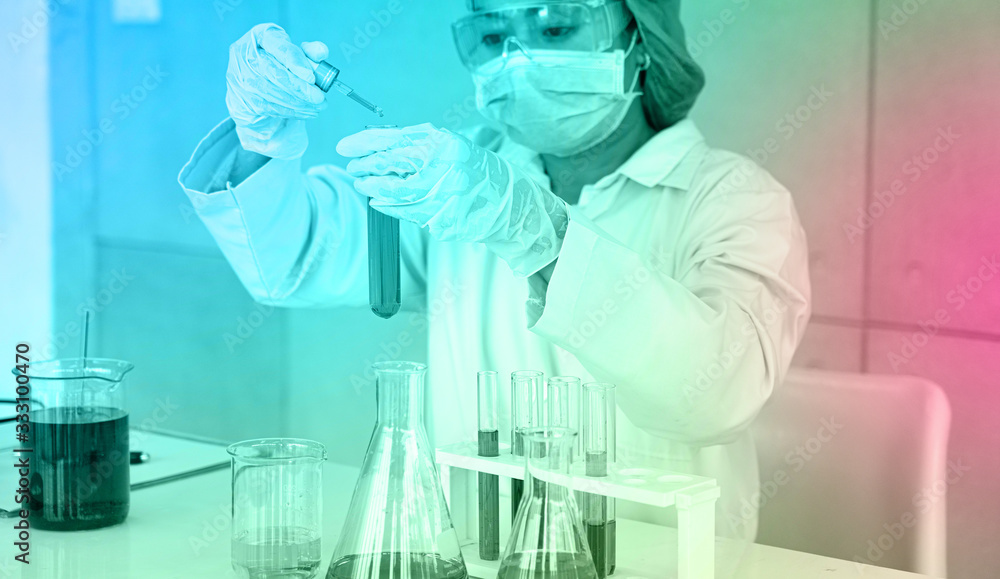 Asian Scientist Pipetting at a Biomedical Laboratory.Focused young life science professional