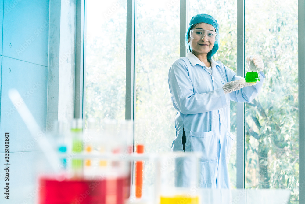 Asian Scientist Pipetting at a Biomedical Laboratory.Focused young life science professional pipetting solution into the glass cuvette. Lens focus Asian Scientist Pipetting at a Biomedical Laboratory.Focused young life science professional pipetting solution into the glass cuvette. Lens focus