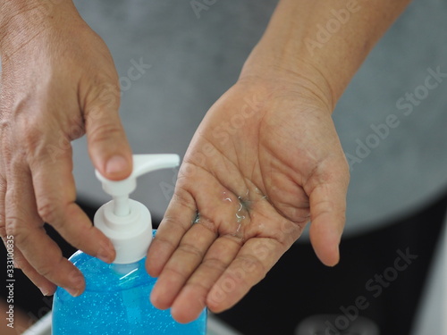 woman standing and pressing a pump bottle  Hand Sanitizer  gel alcoholic mixture with gelatin in clear Plastic bottle  washing clean dirty to prevent germs protect colona virus  covid 19