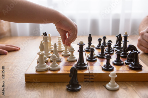 Dad and Son playing chess together at home