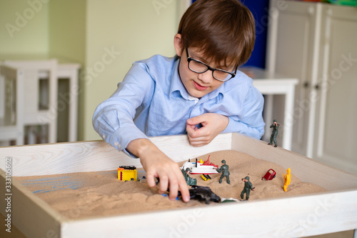 Obraz na plátně boy glasses is sand therapy on table with light