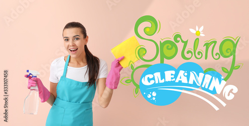Female janitor with supplies on color background. Spring cleaning