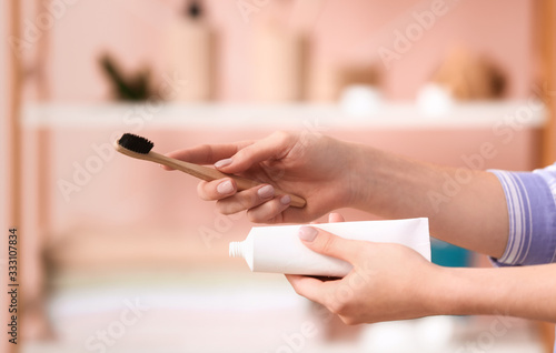 Woman with tooth brush and paste in bathroom