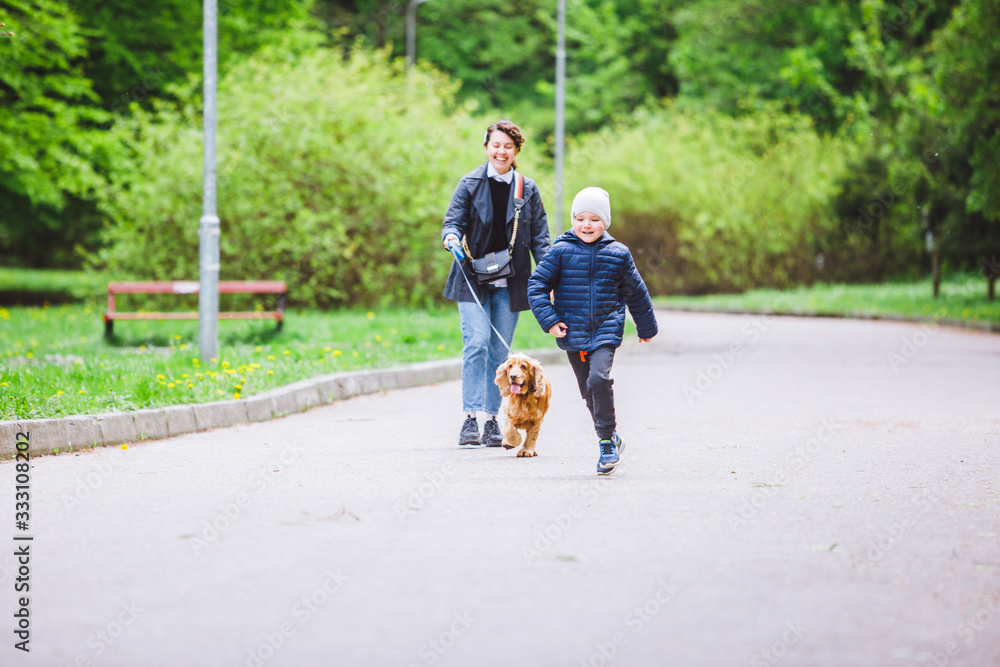 young woman with little kid and dog on leash walking at city park young woman with little kid and dog on leash walking at city park