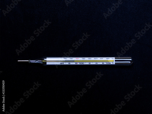 Mercury thermometer on black background.
